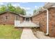 Back patio with a well-kept lawn, brick exterior, and walkway, offering an outdoor living space at 410 W Tenth St, Siler City, NC 27344