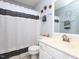 Well-lit bathroom featuring white vanity, decorative mirror and stylish shower curtain at 412 Onondaga Ct, Holly Springs, NC 27540