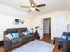 Comfortable bonus room featuring a plush gray couch, exercise bike, and ceiling fan at 412 Onondaga Ct, Holly Springs, NC 27540