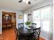 Bright dining area with black table and chairs complemented by natural light from the window and view into dining room at 412 Onondaga Ct, Holly Springs, NC 27540