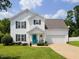 Charming two-story home with a well-manicured lawn, two-car garage and inviting turquoise front door at 412 Onondaga Ct, Holly Springs, NC 27540
