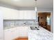 Bright kitchen featuring white cabinets, stainless steel sink and granite countertops, flowing into a dining area at 412 Onondaga Ct, Holly Springs, NC 27540