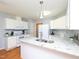 Modern kitchen with granite countertops, white cabinetry, and stainless steel appliances at 412 Onondaga Ct, Holly Springs, NC 27540