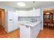 Bright kitchen featuring white cabinets, stainless steel sink and granite countertops, flowing into a dining area at 412 Onondaga Ct, Holly Springs, NC 27540