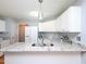 Bright kitchen features a granite countertop island and white cabinetry, offering a modern and clean design at 412 Onondaga Ct, Holly Springs, NC 27540