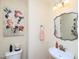 Quaint powder room with decorative mirror, floral artwork, and stylish fixtures at 412 Onondaga Ct, Holly Springs, NC 27540