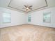 Large bedroom with neutral carpet, tray ceiling, and plenty of natural light at 425 Sunny Field Dr., Wake Forest, NC 27587