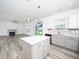 Bright, open kitchen featuring an island, stainless steel appliances, and sleek gray and white cabinets at 425 Sunny Field Dr., Wake Forest, NC 27587