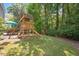 Shaded backyard with a playset and picnic area at 4524 Drewbridge Way, Raleigh, NC 27604