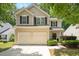 Charming two-story home boasts a two-car garage and classic curb appeal with lush landscaping and a welcoming entrance at 4524 Drewbridge Way, Raleigh, NC 27604