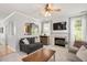 Cozy living room with a fireplace, large windows with natural light, and an archway leading to the kitchen at 4524 Drewbridge Way, Raleigh, NC 27604