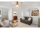 Open-concept living room with archway to kitchen, neutral tones, carpet, and ample seating at 4524 Drewbridge Way, Raleigh, NC 27604