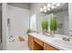 Well-lit main bathroom with double sinks, large mirror, soaking tub, and decorative plants at 4524 Drewbridge Way, Raleigh, NC 27604