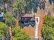 Stunning aerial of charming home surrounded by trees, firepit, long driveway and lush greenery at 506 Tirzah Dr, Lillington, NC 27546
