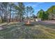 Fire pit surrounded by mature trees and lush greenery, creating a cozy outdoor space at 506 Tirzah Dr, Lillington, NC 27546