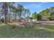 Expansive backyard with mature trees, a fire pit, and a detached garage at 506 Tirzah Dr, Lillington, NC 27546