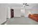 Bonus room features neutral walls, carpet, ceiling fan, and a comfortable couch at 506 Tirzah Dr, Lillington, NC 27546