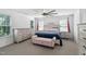 Bright bedroom featuring a ceiling fan, dresser, bench and neutral carpet at 5125 Pinehall Wynd, Raleigh, NC 27604
