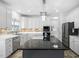 Bright kitchen with white cabinets, stone backsplash, stainless steel appliances, and a dark granite island at 5125 Pinehall Wynd, Raleigh, NC 27604