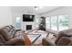 Living area with hardwood floors, a fireplace, mounted tv, and lots of light from the windows at 5125 Pinehall Wynd, Raleigh, NC 27604
