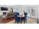 Living area with hardwood floors, a fireplace, a mounted tv, and blue chairs around a small table at 5125 Pinehall Wynd, Raleigh, NC 27604