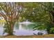 Beautiful view of a tranquil pond with a fountain, framed by mature trees at 5125 Pinehall Wynd, Raleigh, NC 27604