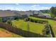 Large backyard featuring a wooden fence, mature trees, and ample space for outdoor activities at 515 Legacy Dr, Youngsville, NC 27596