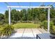 View of the expansive backyard with a white pergola and lush trees beyond the fence at 515 Legacy Dr, Youngsville, NC 27596