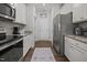 Galley kitchen with stainless steel appliances, white cabinets, and granite countertops at 515 Legacy Dr, Youngsville, NC 27596