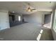 Spacious living room with modern flooring, a ceiling fan, and a partial view of kitchen at 57 Faucette Dr, Selma, NC 27576