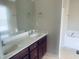 Bathroom featuring a double sink vanity with wood cabinets and a separate soaking tub at 5908 Abbington Way, Raleigh, NC 27610