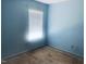 Bedroom with bare floors, light blue walls, and a window with blinds at 5908 Abbington Way, Raleigh, NC 27610