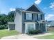 Side view of a two-story home featuring gray siding, black shutters, and a well-manicured lawn at 5908 Abbington Way, Raleigh, NC 27610