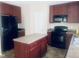 Spacious kitchen with cherry wood cabinets, black appliances, and a center island at 5908 Abbington Way, Raleigh, NC 27610