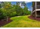 Large backyard featuring green grass and a backdrop of mature trees at 610 Bennett Mountain, Chapel Hill, NC 27516