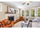 Cozy living room with a fireplace, hardwood floors, and ample natural light from large windows at 610 Bennett Mountain, Chapel Hill, NC 27516