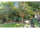 Lush backyard with mature trees, manicured landscaping, and stone-lined flower beds at 6412 Forest Ridge Dr, Durham, NC 27713