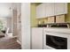 Functional laundry room with washer, dryer, storage cabinets, and shelving at 6412 Forest Ridge Dr, Durham, NC 27713
