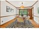 Dining room features a modern light fixture, wood floors, and outside views at 6728 Glen Forrest Dr, Chapel Hill, NC 27517