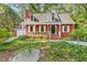 Charming red home with a front porch, white trim, and a well-maintained landscaped yard at 6728 Glen Forrest Dr, Chapel Hill, NC 27517