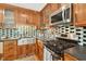 Modern kitchen featuring stainless steel appliances, black countertops, and tile backsplash at 6728 Glen Forrest Dr, Chapel Hill, NC 27517