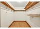 Spacious walk-in closet with hardwood floors and ample shelving, maximizing storage and organization at 6728 Glen Forrest Dr, Chapel Hill, NC 27517