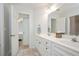 White bathroom featuring double vanity, large mirror and modern fixtures at 8512 Barrett Hall Ln, Wake Forest, NC 27587