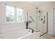 Bright bathroom featuring soaking tub, walk-in shower, and large windows at 8512 Barrett Hall Ln, Wake Forest, NC 27587