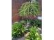 Charming front yard featuring decorative tree, statue and vibrant plants against a brick home at 8512 Barrett Hall Ln, Wake Forest, NC 27587