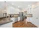 Open kitchen with stainless steel appliances, custom cabinets, and hardwood floors at 8512 Barrett Hall Ln, Wake Forest, NC 27587