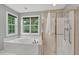 Bathroom featuring a soaking tub with jets and a separate glass shower with brass trim at 9 Monteith Ct, Durham, NC 27713