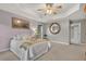 Comfortable main bedroom featuring a tray ceiling, a ceiling fan, and soft carpet flooring at 9 Monteith Ct, Durham, NC 27713