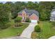 Aerial view of a brick two-story home surrounded by mature trees and green lawn at 9 Monteith Ct, Durham, NC 27713