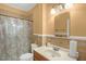 Traditional bathroom featuring tiled walls, vanity sink, and a shower with curtain at 907 Morehead Ave, Durham, NC 27707